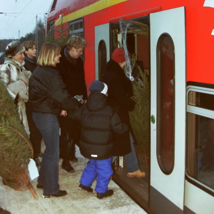 Einstieg mit Weihnachtsbäumen in den Zug im Winter 2003