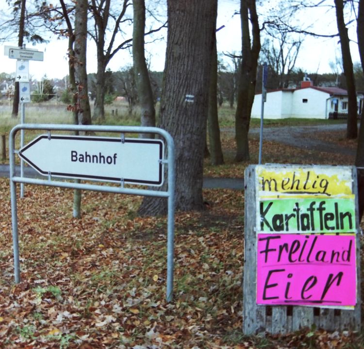 Bahnhof-Hinweisschild in Verbindung mit örtlichen Angeboten